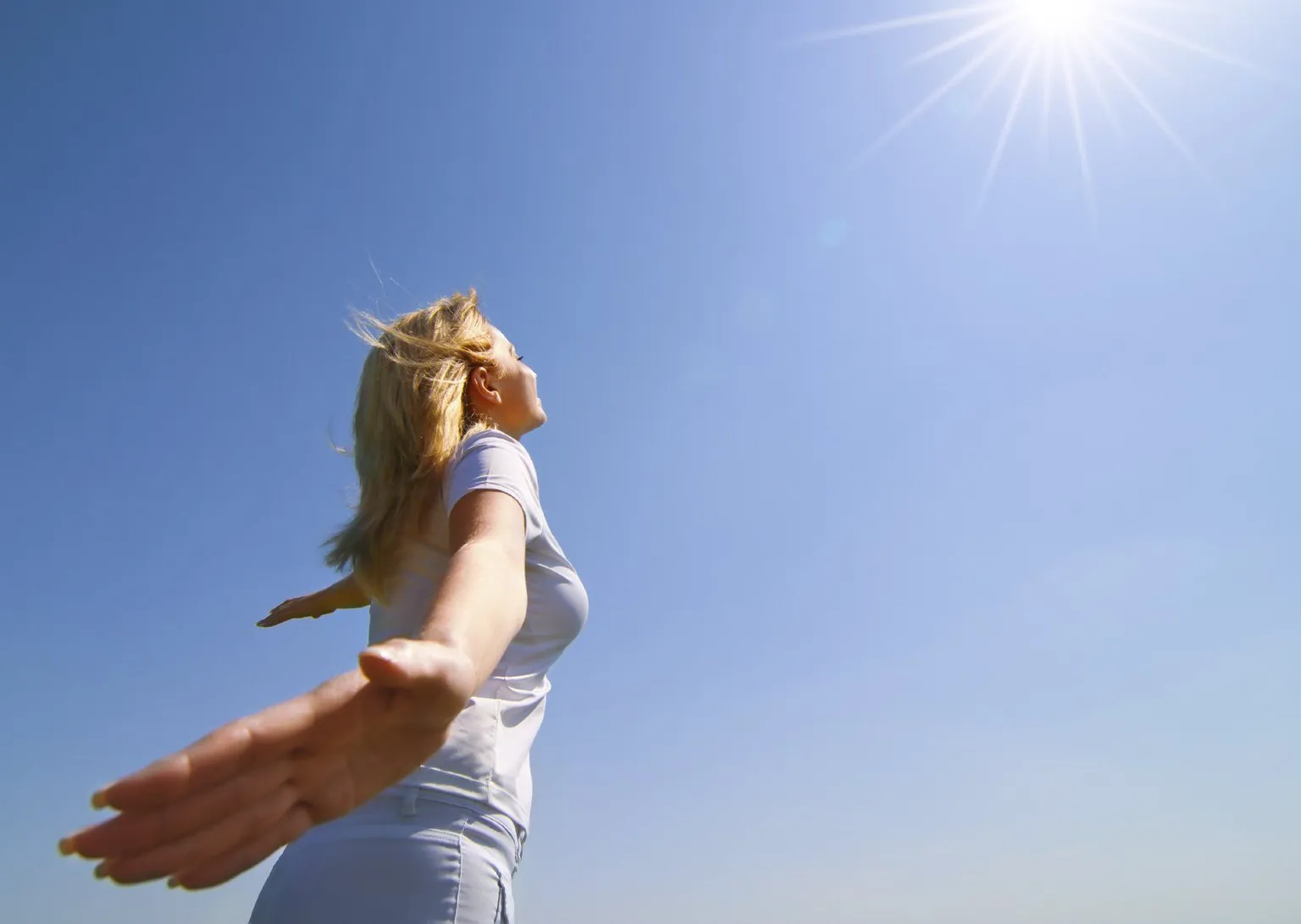 A woman opening her arms to the sky, suggesting a lighter, more open way of thinking